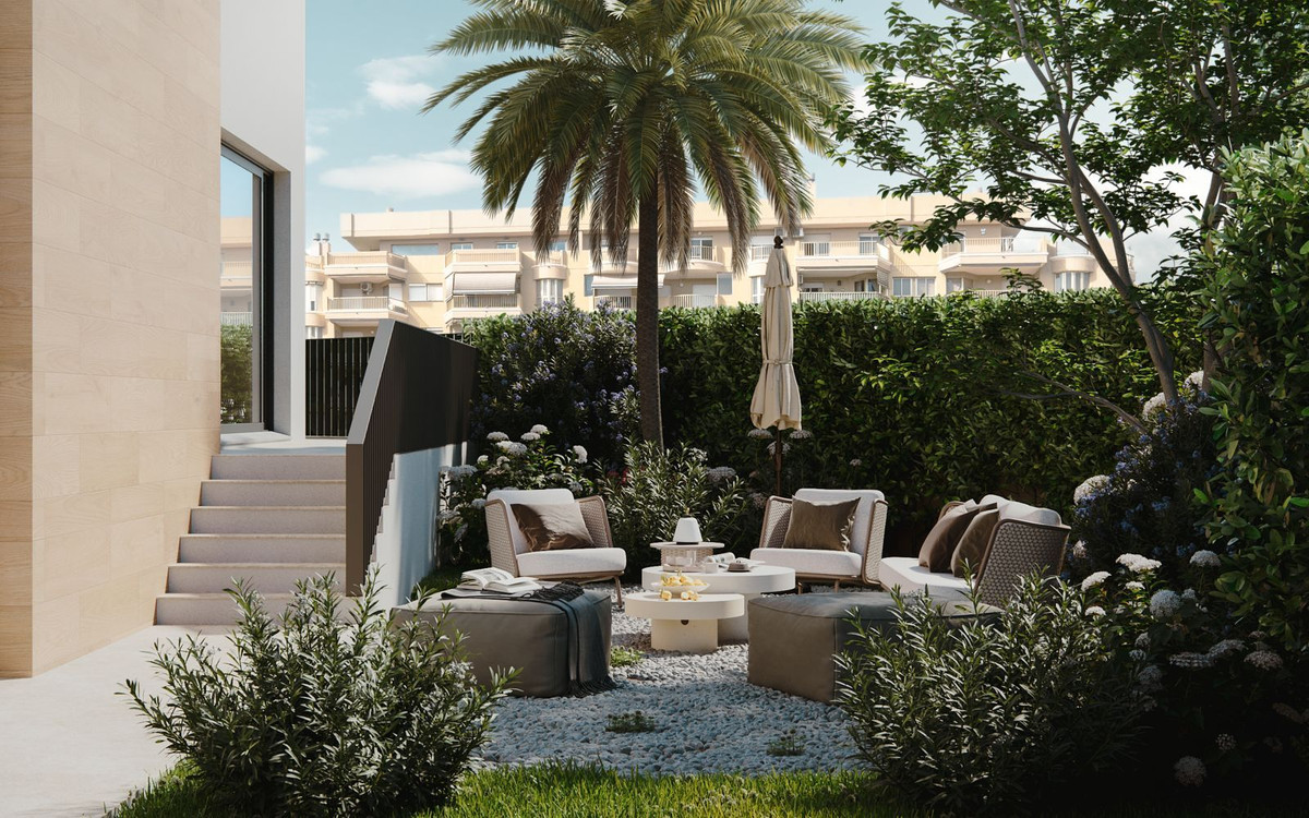 Modern patio with lounge chairs, palm tree, and ocean view.