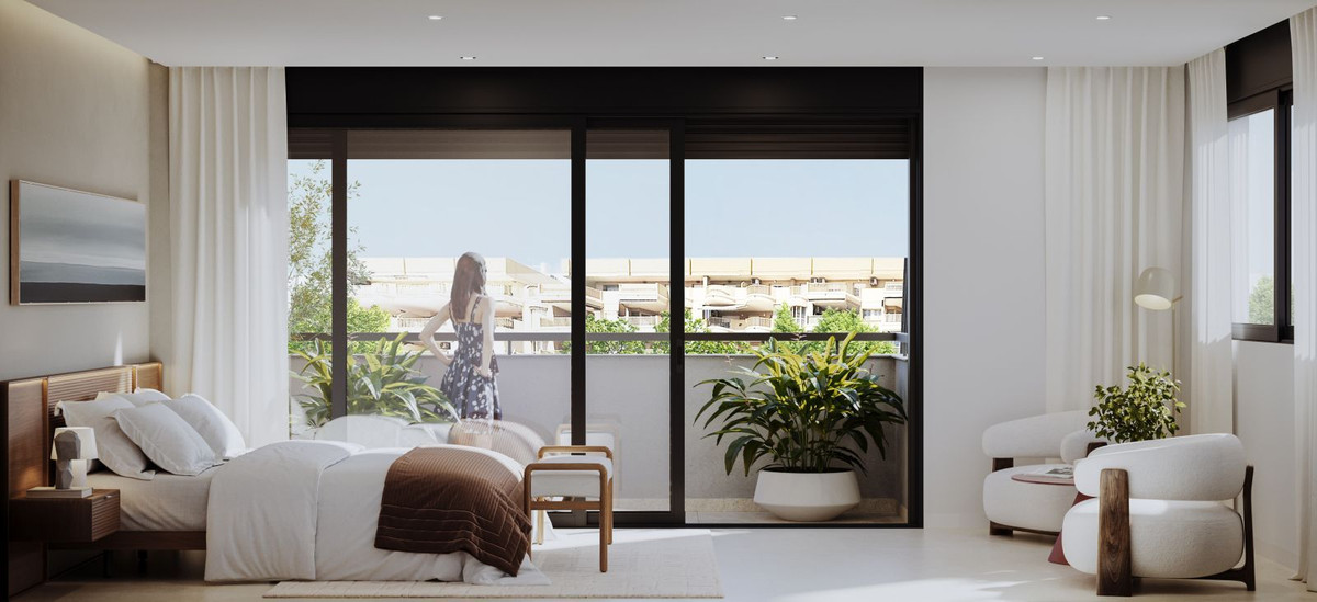 Modern bedroom with balcony, large windows, and city view.